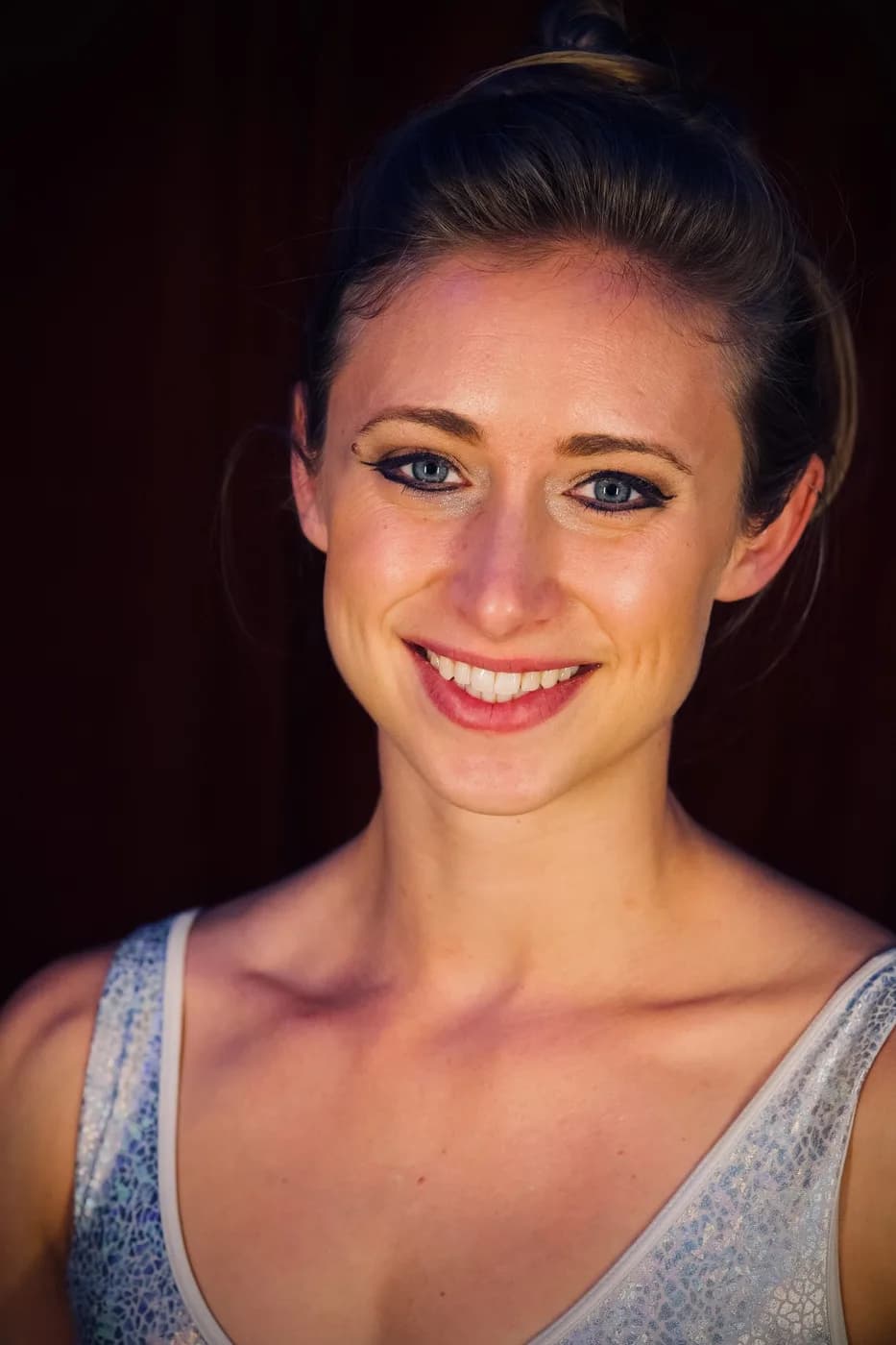 Katie Herndon, smiling, photographed against a dark background.